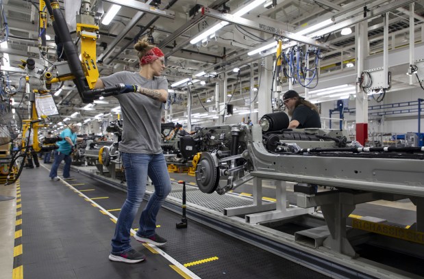 Workers build chassis on the assembly line at the Rivian electric vehicle plant in Normal.