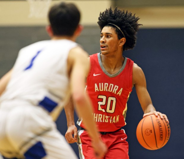 Aurora Christian's Jalen Carter (20) looks to pass as Rochelle Zell's Jesse Shapira (1) defends during the Class 1A Harvest Christian Sectional semifinal on Tuesday, Feb. 27, 2024 in Elgin. Aurora Christian advanced with the 64-56 win.H. Rick Bamman / For the Beacon-News