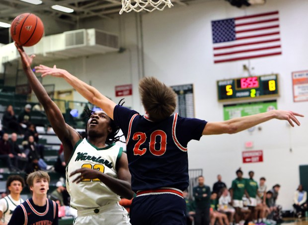 Waubonsie Valley's Matthew Sessom goes for the basket as Naperville North's Grant Montanari defends during the boys basketball game in Aurora, Wednesday, February 14, 2024. (James C. Svehla-Beacon News)