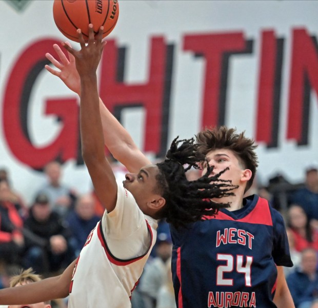 West Aurora's Gabriel Gonzales blocks the shot of Yorkville's Michael Dunn. West Aurora defeated Yorkville 64-53 in a Class 4A Yorkville Regional semifinal boys basketball game Wednesday, February 21, 2024, in Yorkville, Illinois. (Jon Langham/photo for the Beacon-News)