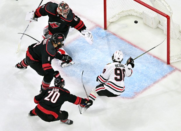 RALEIGH, NORTH CAROLINA - FEBRUARY 19: Connor Bedard #98 of the Chicago Blackhawks scores a goal against goaltender Spencer Martin #41, Sebastian Aho #20 and Brent Burns #8 of the Carolina Hurricanes during the game at PNC Arena on February 19, 2024 in Raleigh, North Carolina. The Hurricanes won 6-3. (Photo by Grant Halverson/Getty Images) ** OUTS - ELSENT, FPG, CM - OUTS * NM, PH, VA if sourced by CT, LA or MoD **