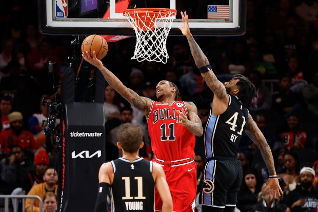 Chicago Bulls forward DeMar DeRozan, center, scores over Atlanta Hawks forward Saddiq Bey, left, during the second half of an NBA basketball game Monday, Feb. 12, 2024, in Atlanta. (AP Photo/Alex Slitz)