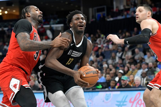 Grizzlies forward Jaren Jackson Jr. (13) looks to the basket between Bulls centers Andre Drummond, left, and Nikola Vucevic Thursday in Memphis, Tenn. The Bulls won 118-110.