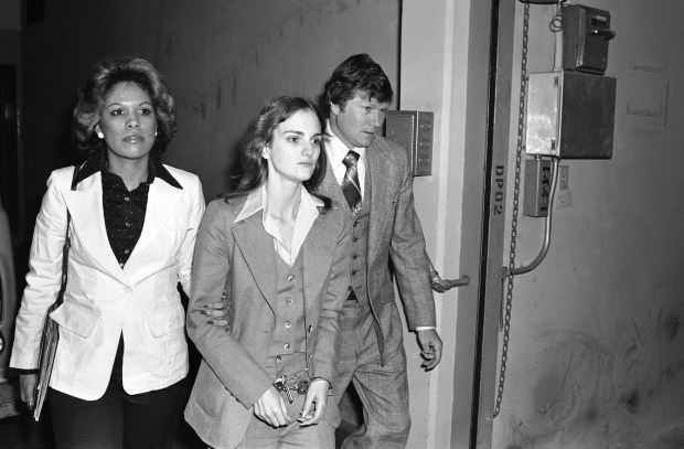 Accompanied by deputy U.S. Marshal John Brophy, Patricia "Patty" Hearst, center, leaves the Federal building on April 12, 1976, in San Francisco, hours after her sentencing on a bank robbery conviction. (AP)