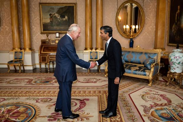 FILE - King Charles III welcomes Rishi Sunak during an audience at Buckingham Palace, London, where he invited the newly elected leader of the Conservative Party to become Prime Minister and form a new government, Oct. 25, 2022. Britain's King Charles III has been diagnosed with cancer and has begun treatment, Buckingham Palace said Monday Feb. 5, 2024. Less than 18 months into his reign, the 75-year-old monarch will suspend public engagements but will continue with state business, and won't be handing over his constitutional roles as head of state. (Aaron Chown/Pool photo via AP, file)