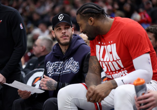 Injured Chicago Bulls guard Lonzo Ball talks with teammate Andre Drummond on the bench in the first half of a game against the Sacramento Kings at the United Center in Chicago on Feb. 3, 2024. (Chris Sweda/Chicago Tribune)