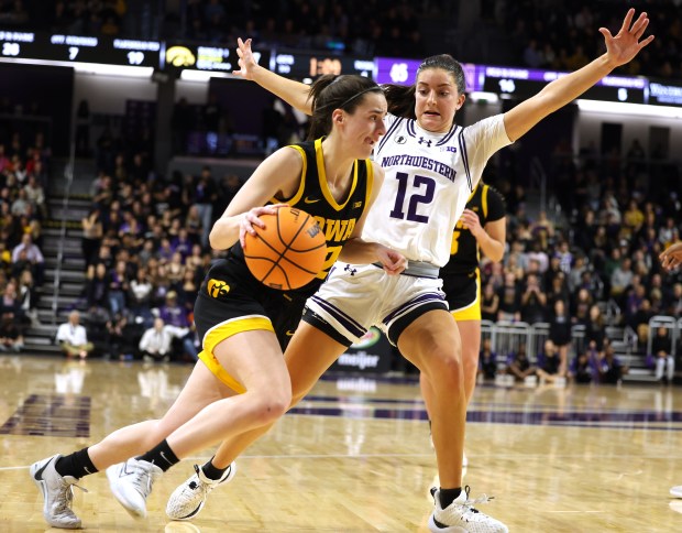 Iowa's Caitlin Clark drives to the basket while being guarded by Northwestern's Casey Harter in the second half at Welsh-Ryan Arena on Jan. 31, 2024. (Stacey Wescott/Chicago Tribune)