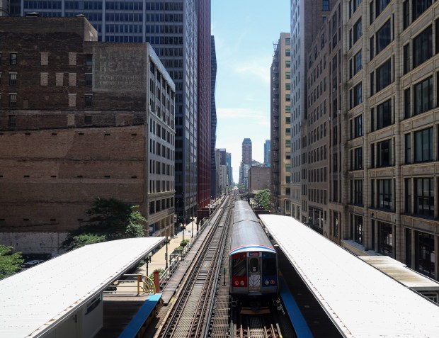 Surrounded by office buildings, a CTA Heritage Fleet train departs the Adams/Wabash station in the Loop on July 29, 2023.