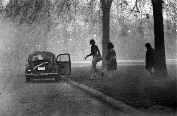 A cloud of hydrochloric acid vapor that escaped from a tank farm at the southeast corner of Lake Calumet hangs like a heavy fog over the Altgeld Gardens housing project on April 26, 1974. Squads of police rushed into the area to urge residents to flee the possibly toxic fumes. Many dashed for their cars, like this group shown here, heading first to Carver High School and then to Fenger High School as fumes seeped into Carver. Some residents were overcome before they could be evacuated and were given oxygen by the fire department ambulance crew. (Don Casper/Chicago Tribune)