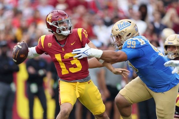 LOS ANGELES, CALIFORNIA - NOVEMBER 18: Caleb Williams #13 of the USC Trojans looks to pass under pressure from Keanu Williams #99 of the UCLA Bruins during the first half of a game against the UCLA Bruins at United Airlines Field at the Los Angeles Memorial Coliseum on November 18, 2023 in Los Angeles, California. (Photo by Sean M. Haffey/Getty Images) ** OUTS - ELSENT, FPG, CM - OUTS * NM, PH, VA if sourced by CT, LA or MoD **