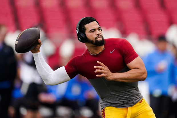 FILE - Southern California quarterback Caleb Williams warms up for the team's NCAA college football game against UCLA, Nov. 18, 2023, in Los Angeles. USC will play its final game as a member of the Pac-12 Conference before moving to the Big Ten next season. Williams, the 2022 Heisman Trophy winner, has opted out, one of many players from both schools who will miss the game due to opting out or entering the transfer portal. (AP Photo/Ryan Sun,File)