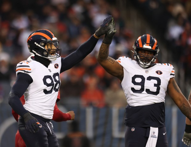 Bears defensive end Montez Sweat (98) and defensive tackle Justin Jones (93) celebrate a batted pass against the Cardinals on Dec. 24, 2023, at Soldier Field. (Trent Sprague/Chicago Tribune)