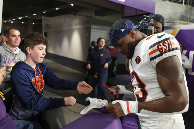 Chicago Bears cornerback Jaylon Johnson (33) signs his gloves for Bears fan Tate Gardner after the Chicago Bears defeated the Minnesota Vikings 12-10 at U.S. Bank Stadium in Minneapolis Nov. 27, 2023. (Eileen T. Meslar/Chicago Tribune)