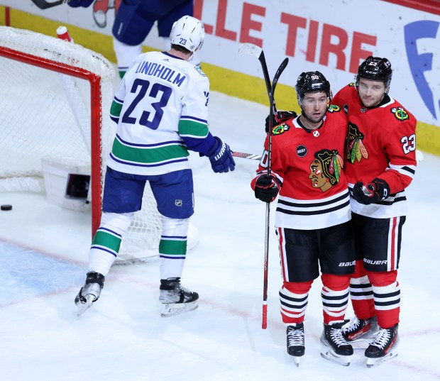 Blackhawks centers Tyler Johnson (90) and Philipp Kurashev (23) celebrate after a goal by Johnson in the second period on Feb. 13, 2024, at the United Center. (Chris Sweda/Chicago Tribune)