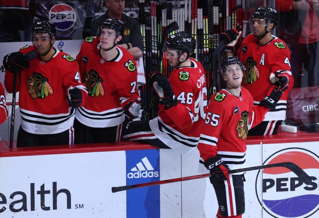 Blackhawks defenseman Kevin Korchinski (55) celebrates with teammates after scoring a goal against the Canucks in the third period Tuesday at the United Center. (Chris Sweda/Chicago Tribune)