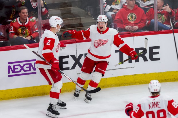 Detroit Red Wings right wing Alex DeBrincat (93) celebrates with Detroit Red Wings defenseman Olli Maatta (2) after scoring during the third period against the Chicago Blackhawks at the United Center Sunday Feb. 25, 2024 in Chicago. (Armando L. Sanchez/Chicago Tribune)