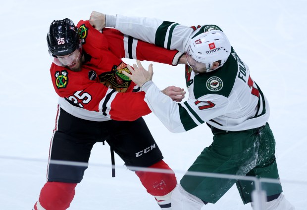 Chicago Blackhawks defenseman Jarred Tinordi (left) and Minnesota Wild left wing Marcus Foligno (right) fight in the second period of a game at the United Center in Chicago on Feb. 7, 2024. (Chris Sweda/Chicago Tribune)