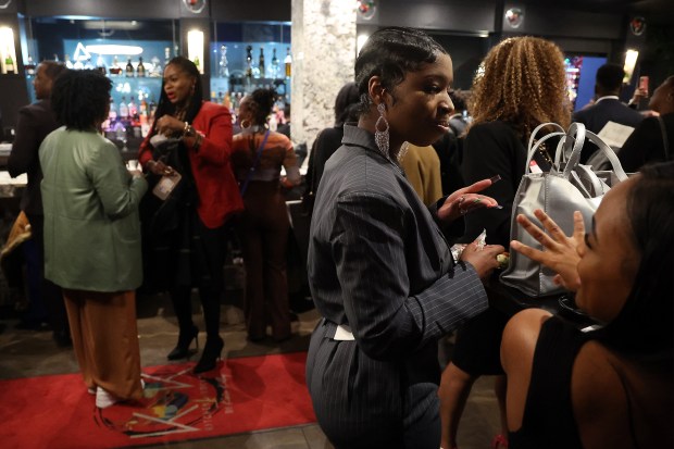 Rhonda Ekwunoh talks to other attendees at Kitchen + Kocktails restaurant in Chicago's River North neighborhood during a Chicago Black Restaurant Week event on Friday, Feb. 9, 2024. (Terrence Antonio James/Chicago Tribune)