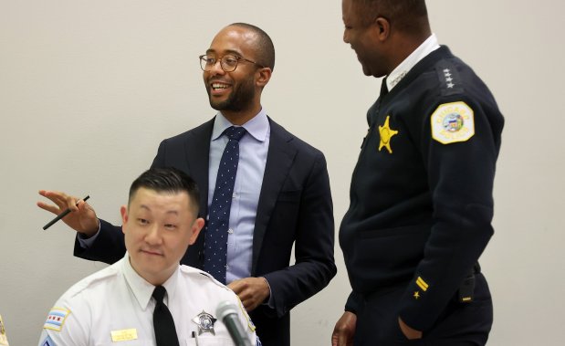 New Chicago Police Board president Kyle Cooper, center, and police Superintendent Larry Snelling, right, meet before a monthly Chicago Police Board meeting on Dec. 21, 2023. (Chris Sweda/Chicago Tribune)