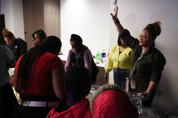 Carmece Barrow, right, director of violence intervention and prevention services at UCAN, says a prayer before clients share a meal as part of the SheRo program on Feb. 9, 2024. (Terrence Antonio James/Chicago Tribune)