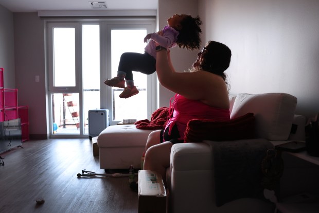 Kimberly Riquelme and daughter Jasmine, 2, hang out at their new apartment on Chicago's North Side on Feb. 19, 2024, while getting ready to attend a WTTW premiere event about a documentary they're featured in. (Chris Sweda/Chicago Tribune)