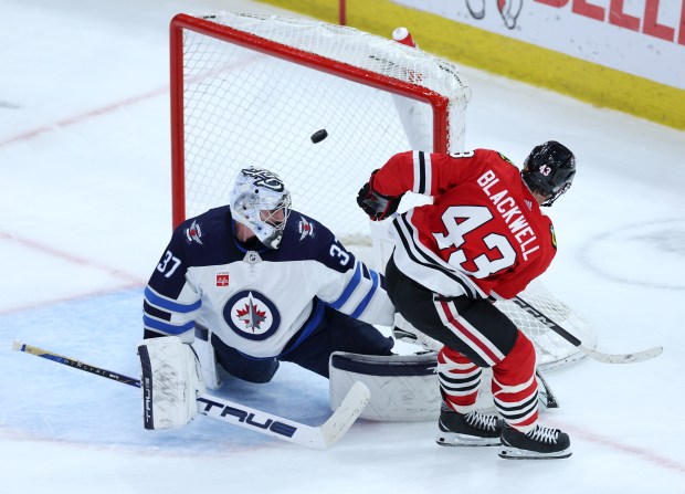 Blackhawks center Colin Blackwell (43) scores on Jets goaltender Connor Hellebuyck in the second period on Feb. 23, 2024, at the United Center. (Chris Sweda/Chicago Tribune)