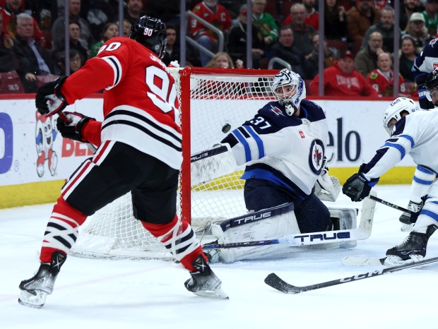 Jets goaltender Connor Hellebuyck is unable to stop the puck as Blackhawks center Tyler Johnson scores the tying goal with 43 seconds left in regulation on Feb. 23, 2024, at the United Center. (Chris Sweda/Chicago Tribune)