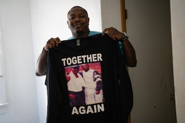 Jermaine Harris holds up the T-shirt he had made when his father, Lee Harris, was finally released from prison in 2023. (E. Jason Wambsgans / Chicago Tribune)