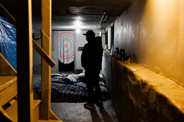 Before walking his children to school, Francisco Hernandez, 31, of Venezuela, stands in the basement where he lives in a home shared by several migrant families in the Roseland neighborhood of Chicago on Jan. 30, 2024. The home is owned by property manager Chris Amatore who said he's housed over 400 migrants in apartments and houses across Chicago. (Armando L. Sanchez/Chicago Tribune)