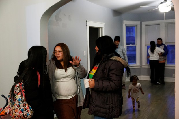 Luiseph Mendoza 32, from left, Joselin Mendoza, 29, and Maria Malpica, 28, all of Venezuela, talk inside a home they share with other migrant families on Jan. 29, 2024 in Chicago. (Armando L. Sanchez/Chicago Tribune)