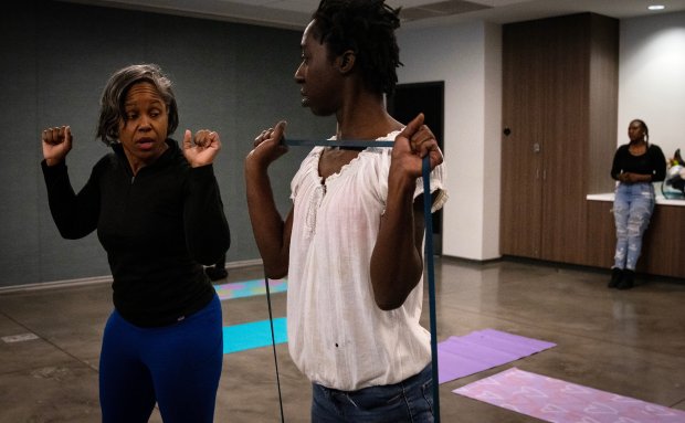 Instructor Michelle Lipscomb, left, guides Stephanie Furlough during a fitness class as part of UCAN's SheRo program, Feb. 7, 2024. (E. Jason Wambsgans/Chicago Tribune)