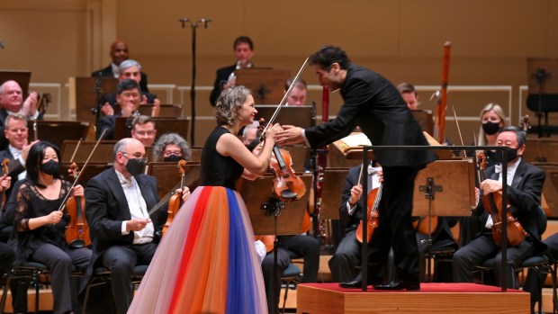 Chicago Symphony Orchestra artist-in-residence Hilary Hahn shakes hands with conductor Andrés Orozco-Estrada during a concert at Symphony Center on Dec. 9, 2021. Orozco-Estrada will open the CSO's next season with a program including Hahn. (Victor Hilitski for the Chicago Tribune)