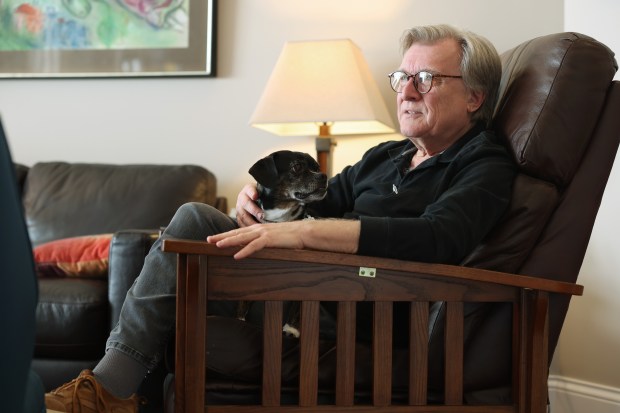 Author Mark Larson sits with his dog, Joey, at home in Chicago. Larson has written a new book titled, "Working in the 21st Century." (John J. Kim/Chicago Tribune)