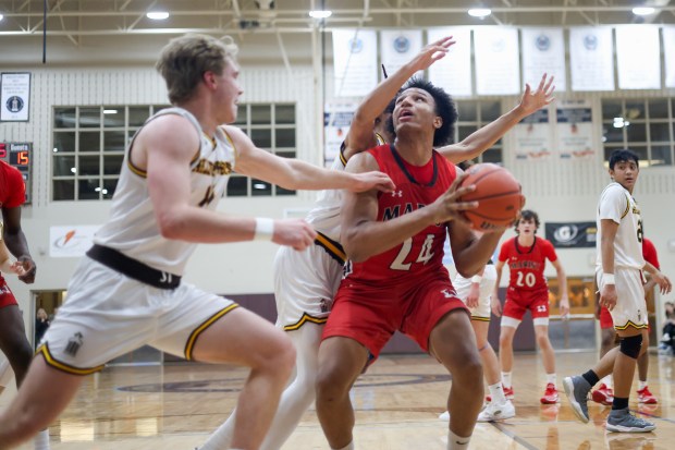 Marist's Achilles Anderson (24) pump fakes a defender during a game against Joliet Catholic Academy in Joliet on Thursday Feb. 8, 2024. (Troy Stolt for the Daily Southtown)