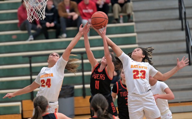 Batavia's Hallie Crane and Addie Prewitt both go for a rebound with Wheaton Warrenville South's Emily Troia. Batavia defeated Wheaton Warrenville South, 55-36, in the Class 4A Bartlett Regional final girls basketball game Friday, February 16, 2024, in Bartlett, Illinois. (Jon Langham/photo for the Beacon-News)