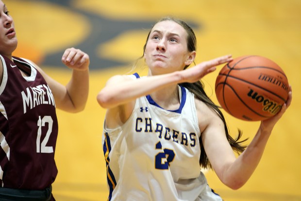 Aurora Central Catholic's Riley Cwinski (23) puts up a basket against Marengo's Gabby Gieseke (12) during a Class 2A Genoa-Kingston Regional semifinal game on Tuesday, Feb. 13, 2024 in Genoa.H. Rick Bamman / For the Beacon News