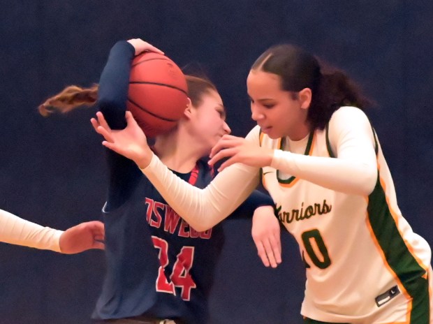 Waubonsie Valley's Danyella Mporokoso battles Oswego's Kaelyn Stager for a rebound. Waubonsie Valley defeated Oswego, 67-43, in a Class 4A Oswego East Regional semifinal girls basketball game Monday, February 12, 2024, in Oswego, Illinois. (Jon Langham/Photo for the Beacon-News)
