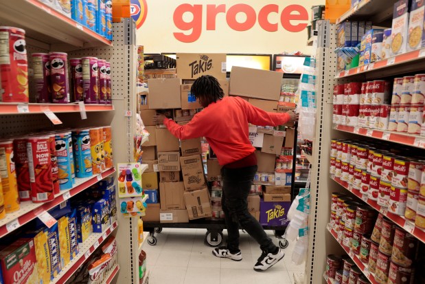 An employee stocks merchandise in the grocery section of the Family Dollar store at 7927 S. Ashland Ave. in Chicago, Jan. 24, 2024.