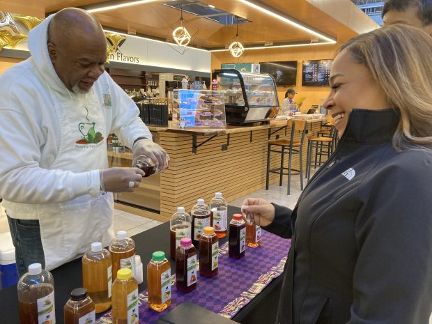 Melody Winston, senior executive of Living Fresh Market, right, samples a tea Feb. 17, 2024 at the store in Forest Park. Living Fresh Market hosted Blackvendors to celebrate Black History Month at the grocery store.