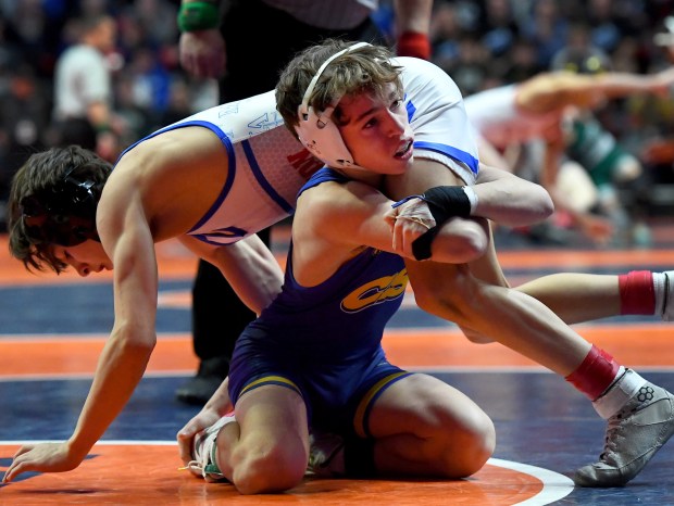 Sandburg's Rocco Hayes holds onto Marmion's Nicholas Garcia in the third-place match at 106 pounds of the Class 3A state meet at the University of Illinois' State Farm Center in Champaign on Saturday, Feb. 18, 2023.