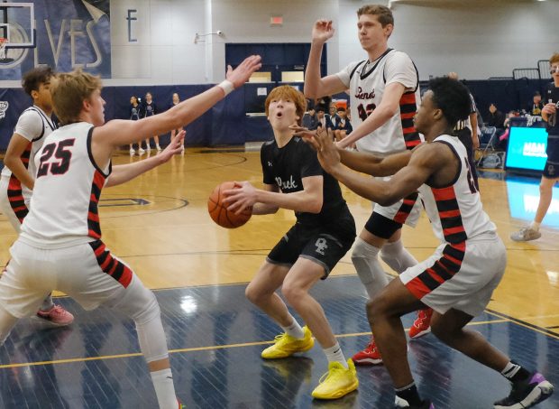 Oswego East's Noah Mason looks to the basket as the Benet defense closes in during the Class 4A Oswego East Regional final game in Oswego on Friday, February 23, 2024.(Jon Cunningham for the Naperville Sun)