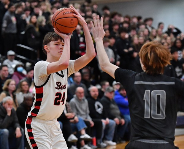 Benet's Daniel Pauliukonis shoots as Oswego East's Noah Mason defends during a Class 4A Oswego East Regional final game in Oswego on Friday, February 23, 2024.(Jon Cunningham for the Naperville Sun)