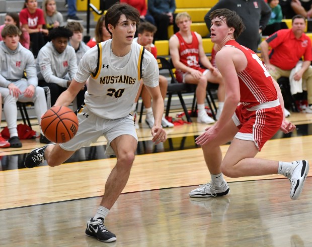 Metea Valley's Alex Danehl (20) drives past Naperville Central's Jack Gervase during a game in Aurora on Wednesday, February 14, 2024.(Jon Cunningham for the Naperville Sun)