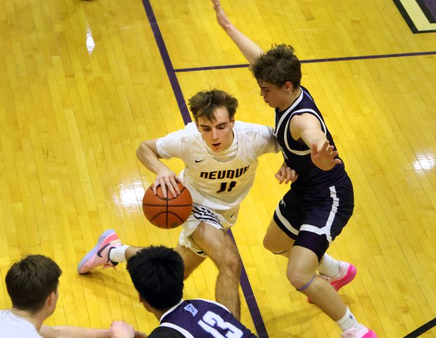 Neuqua Valley's Whitman Charboneau drives to the basket as Downers Grove South's Will Potter and Richard Gasmen defend in the Class 4A Downers Grove North Regional semifinals basketball game in Downers Grove, Wednesday, February 21, 2024. (James C. Svehla-Naperville Sun)