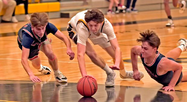 Naperville North's Grant Montanari and Cole Arl dive for a loose ball as Metea Valley's Jake Nosek tries to gain posession. Naperville North lost to Metea Valley, 53-48, in boys basketball Friday, February 9, 2024, in Aurora, Illinois. (Jon Langham/Photo for Naperville Sun)