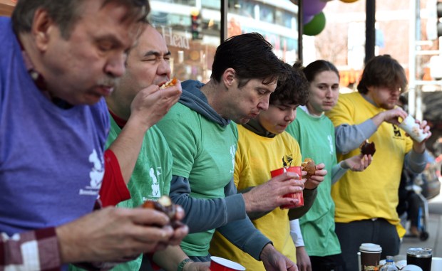 From left to right, are future first place winners Frank Wach of Norwood Park and Teddy Delacruz of Wood Dale. Also seen from left, (starting next to Delacruz) are father and son team Jeffrey Trzaskus of Evanston and Elijah Trzaskus, 15, a high school freshman, at the annual Paczki Eating Contest at Bennison's Bakery in Evanston on Feb. 10, 2024.