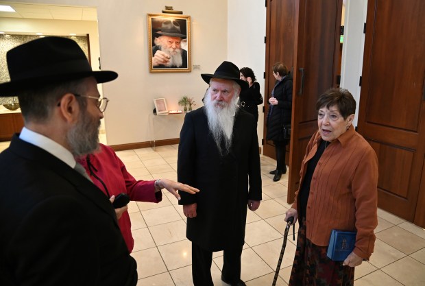 Third from left, center, Rabbi Manis Friedman of Brooklyn, New York converses with attendees as they arrive to Chabad Center for Jewish Life and Learning in Wilmette on Feb. 9, 2024. On far right is Ruth Gilbert of Evanston.