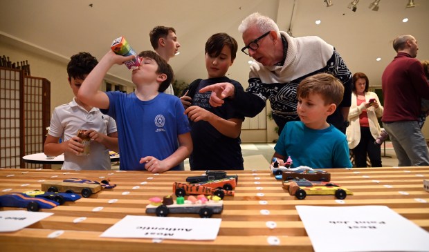 Top right, at the staging rack, looking at cars with other derby fans before racing is Mike McCauley of Winnetka at the Cub Scout Pack 18 Pinewood Derby on Jan. 31, 2024 in Winnetka at Winnetka Presbyterian Church (1255 Willow Road).
