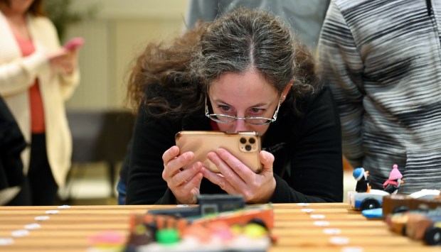 Allyson Jacobson of Winnetka takes a photo to remember the car made by son Daniel Albrecht, 10, a fifth-grader at the Cub Scout Pack 18 Pinewood Derby on Jan. 31, 2024 in Winnetka at Winnetka Presbyterian Church (1255 Willow Road).