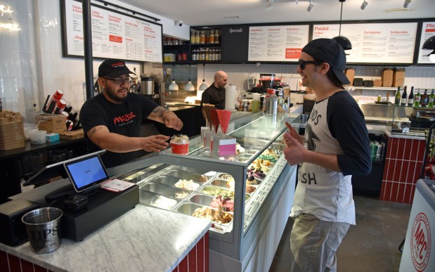 Left, Pedro Cabrales of Berwyn, manager, is in the process of handing gelato to an Elmwood Park resident and customer at Chef Massa Cafe Italiano (7434 W. North Ave.) in Elmwood Park on Feb. 27, 2024. (Karie Angell Luc/Pioneer Press)